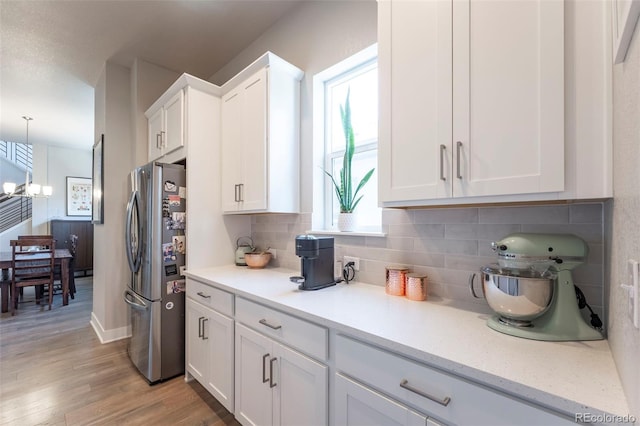 21574 E 59th Dr, Aurora, CO 80019 - kitchen featuring freestanding refrigerator, plenty of natural light, white cabinetry, and tasteful backsplash