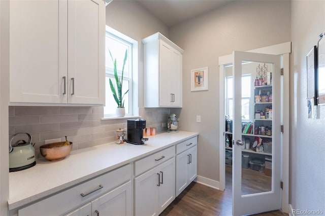 21574 E 59th Dr, Aurora, CO 80019 - kitchen featuring white cabinetry, decorative backsplash, light countertops, and dark wood-style flooring