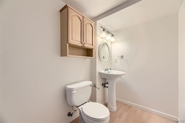 2950 Wyecliff Ln, Highlands Ranch, CO 80126 - half bathroom with toilet, baseboards, wood finished floors, and a sink