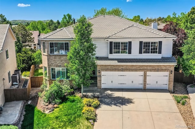 2950 Wyecliff Ln, Highlands Ranch, CO 80126 - traditional-style house with brick siding, concrete driveway, an attached garage, a chimney, and a tile roof