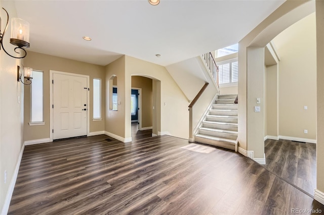 2950 Wyecliff Ln, Highlands Ranch, CO 80126 - foyer entrance with arched walkways, dark wood finished floors, recessed lighting, stairway, and baseboards
