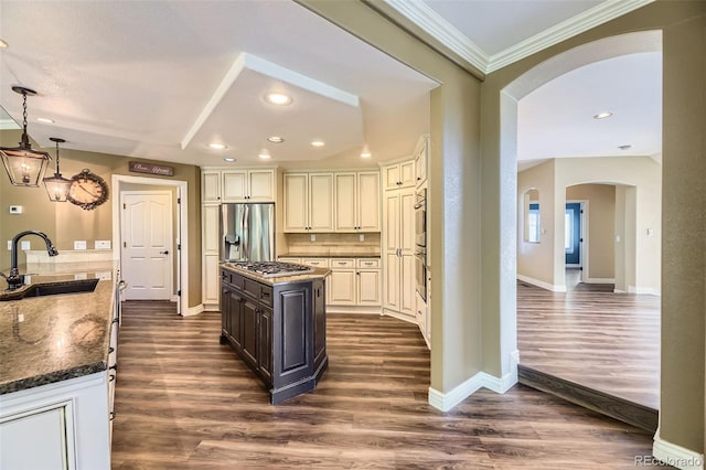 2950 Wyecliff Ln, Highlands Ranch, CO 80126 - kitchen featuring arched walkways, a sink, stainless steel appliances, a kitchen island, and ornamental molding