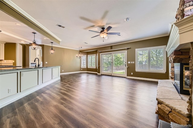2950 Wyecliff Ln, Highlands Ranch, CO 80126 - unfurnished living room featuring a ceiling fan, a stone fireplace, healthy amount of natural light, baseboards, and crown molding