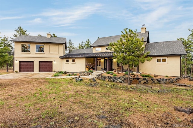 459 County Road 85, Guffey, CO 80820 - view of front of home featuring concrete driveway, an attached garage, a chimney, and stucco siding