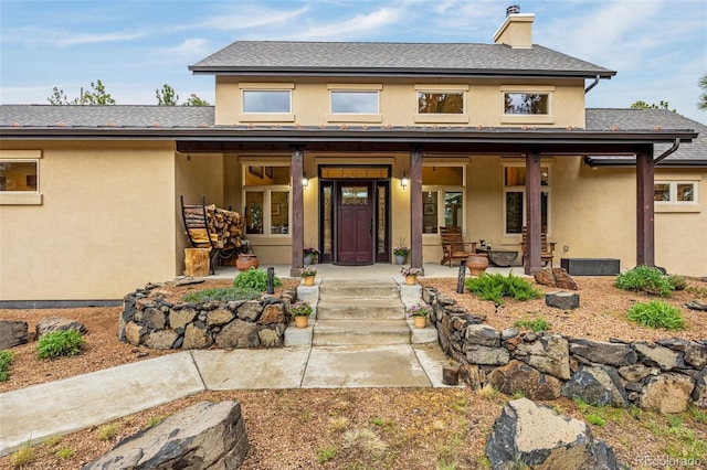 459 County Road 85, Guffey, CO 80820 - view of front of house featuring a porch, a chimney, stucco siding, and roof with shingles