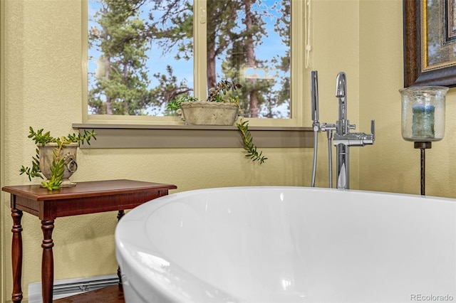 459 County Road 85, Guffey, CO 80820 - bathroom with a freestanding bath, a textured wall, a baseboard heating unit, and a sink