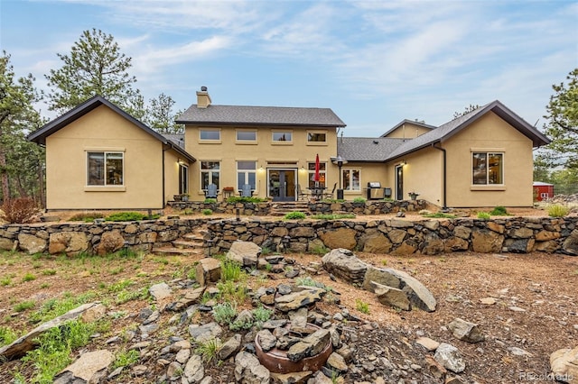 459 County Road 85, Guffey, CO 80820 - view of front of house with a chimney, french doors, a patio, and stucco siding