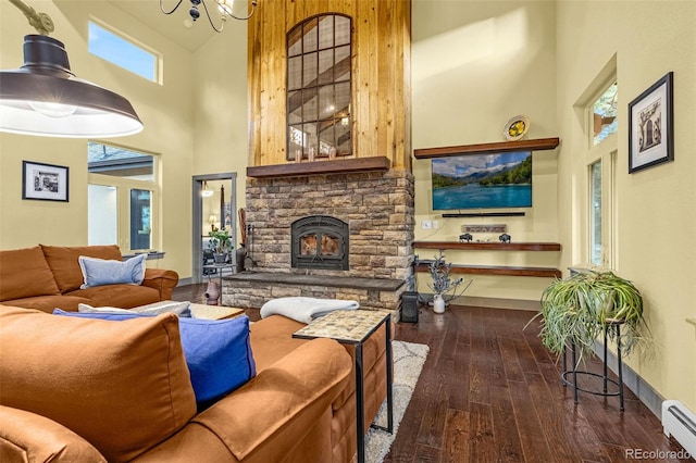 459 County Road 85, Guffey, CO 80820 - living room featuring a towering ceiling, a baseboard heating unit, a fireplace, dark wood-type flooring, and a chandelier