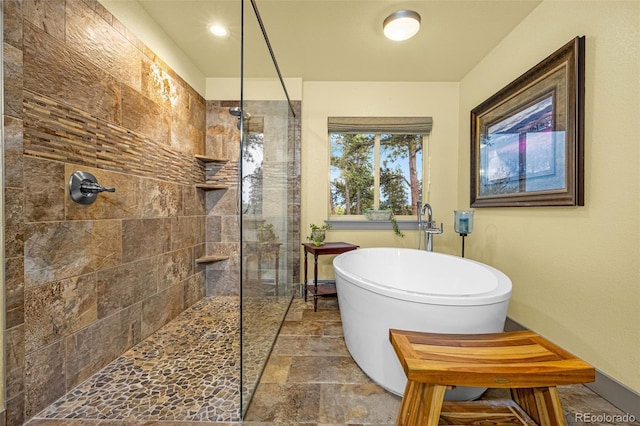 459 County Road 85, Guffey, CO 80820 - full bath featuring a walk in shower, a freestanding tub, stone finish floors, and baseboards