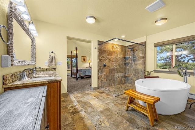 459 County Road 85, Guffey, CO 80820 - ensuite bathroom featuring a shower stall, a soaking tub, double vanity, a textured ceiling, and baseboards