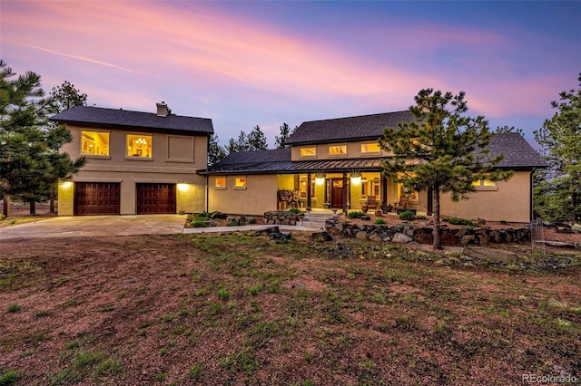 459 County Road 85, Guffey, CO 80820 - view of front facade with concrete driveway, a garage, covered porch, a standing seam roof, and stucco siding