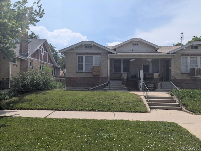 1415 Raleigh St, Denver, CO 80204 - bungalow featuring brick siding, a front lawn, covered porch, and stairs