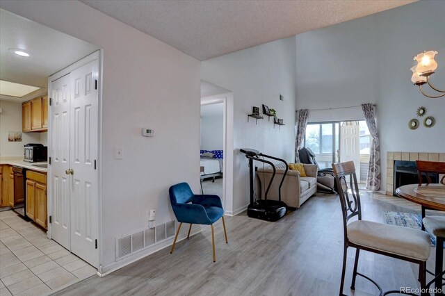 11115 E Alameda Ave Unit 201, Aurora, CO 80012 - living room featuring light wood-style floors, baseboards, a fireplace, and visible vents