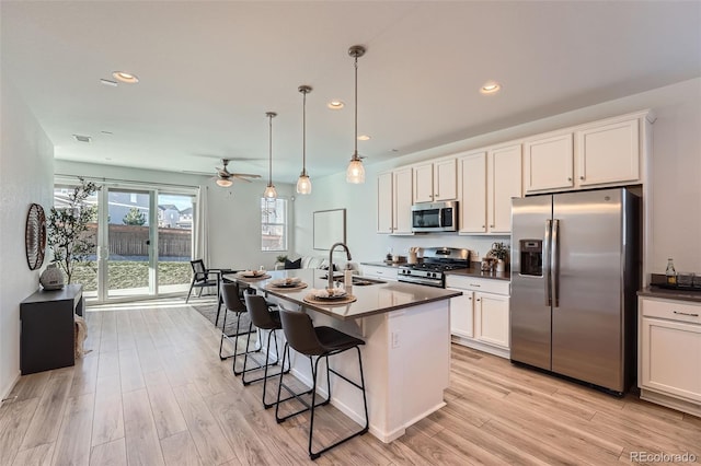 kitchen featuring ceiling fan, sink, pendant lighting, appliances with stainless steel finishes, and light wood-type flooring