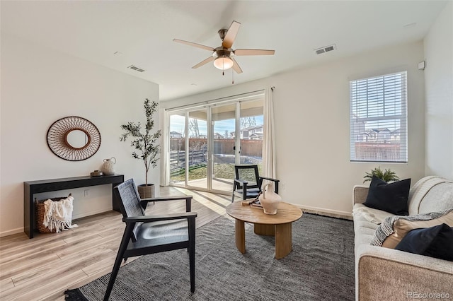 living room featuring light wood-type flooring and ceiling fan