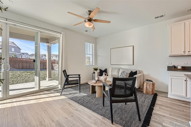 sitting room with ceiling fan and light wood-type flooring