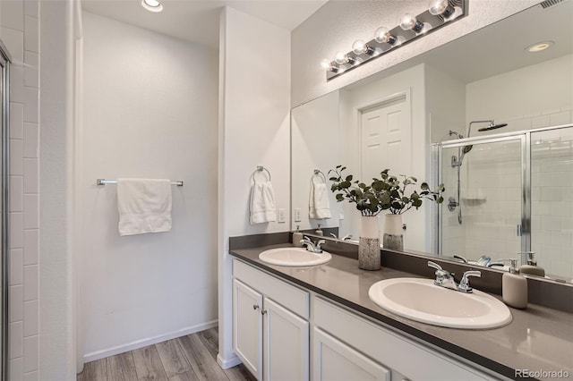 bathroom featuring a shower with door, vanity, and hardwood / wood-style flooring