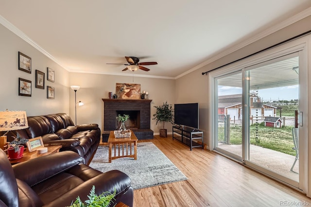 6646 S Fundy Ct, Centennial, CO 80016 - living area featuring a ceiling fan, ornamental molding, light wood-type flooring, a brick fireplace, and baseboards