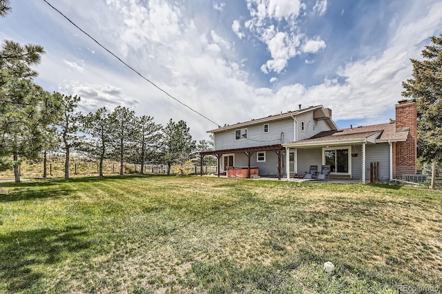 6646 S Fundy Ct, Centennial, CO 80016 - rear view of property with a hot tub, a patio area, a chimney, and a yard