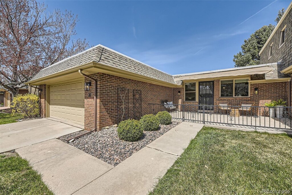 32 Eagle Dr, Littleton, CO 80123 - view of front of home with an attached garage, driveway, and brick siding