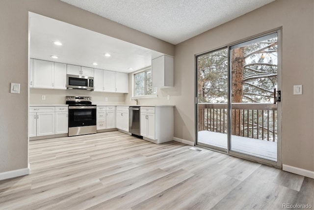 kitchen featuring plenty of natural light, white cabinets, and stainless steel appliances