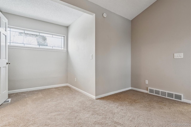 empty room featuring carpet and a textured ceiling