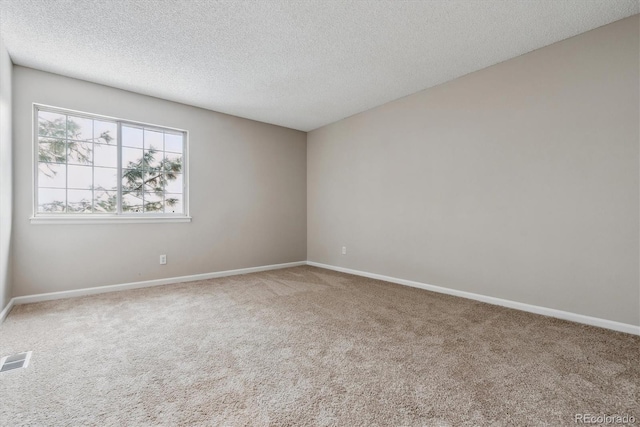 carpeted empty room with a textured ceiling