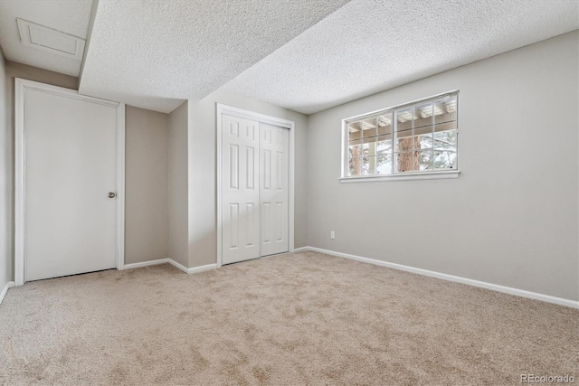 unfurnished bedroom with a textured ceiling, light carpet, and a closet