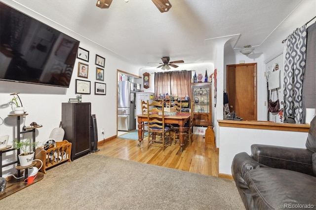 dining room with a textured ceiling, light hardwood / wood-style floors, and ceiling fan