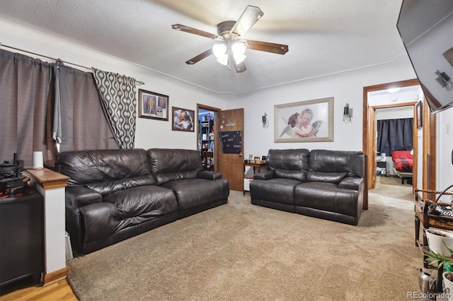 carpeted living room featuring a textured ceiling and ceiling fan