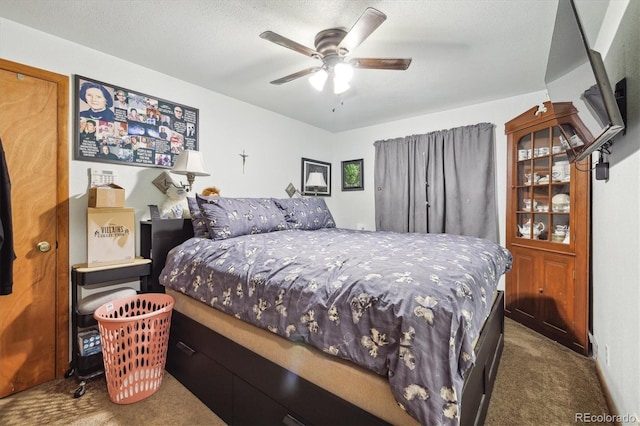 bedroom with dark colored carpet, a textured ceiling, and ceiling fan