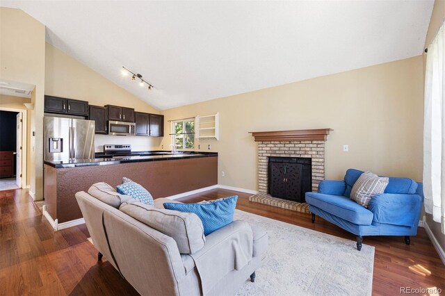 4786 S Yampa St, Aurora, CO 80015 - living area with dark wood-type flooring, high vaulted ceiling, a fireplace, and rail lighting
