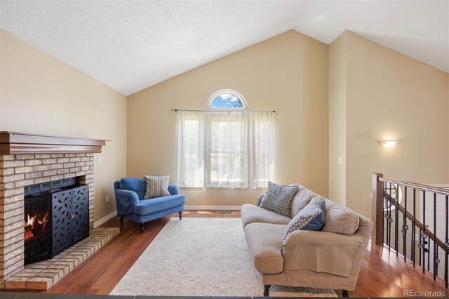 4786 S Yampa St, Aurora, CO 80015 - living area featuring a fireplace, wood finished floors, and high vaulted ceiling
