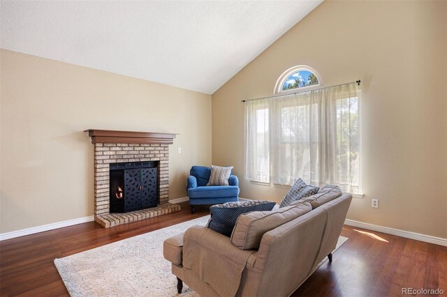 4786 S Yampa St, Aurora, CO 80015 - living room featuring high vaulted ceiling, dark wood finished floors, and a brick fireplace