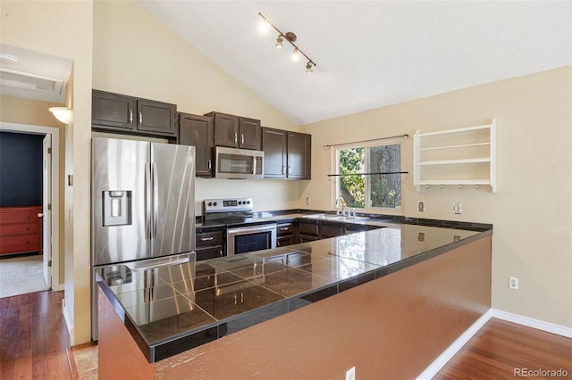 4786 S Yampa St, Aurora, CO 80015 - kitchen featuring stainless steel appliances, tile counters, light wood-style floors, vaulted ceiling, and open shelves