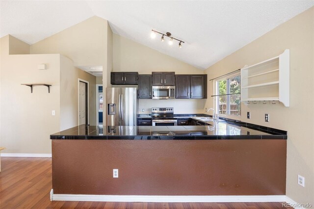 4786 S Yampa St, Aurora, CO 80015 - kitchen featuring appliances with stainless steel finishes, a peninsula, wood finished floors, open shelves, and dark countertops