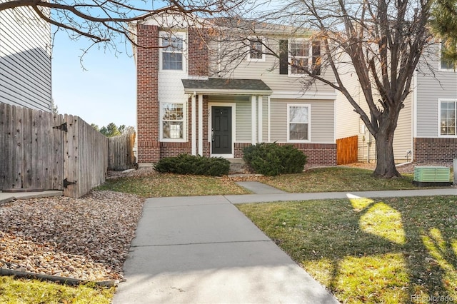 view of front of house with central AC unit and a front lawn