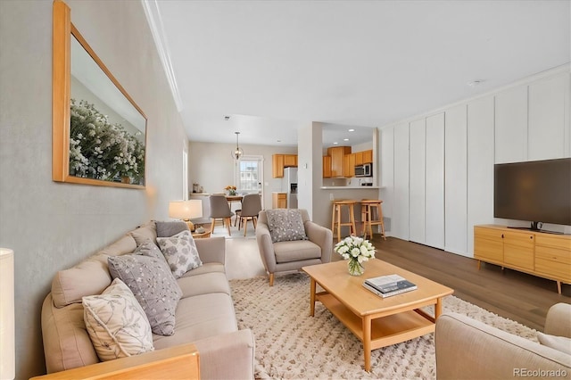 living room with light hardwood / wood-style floors and crown molding