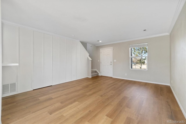 unfurnished room featuring ornamental molding and light hardwood / wood-style flooring