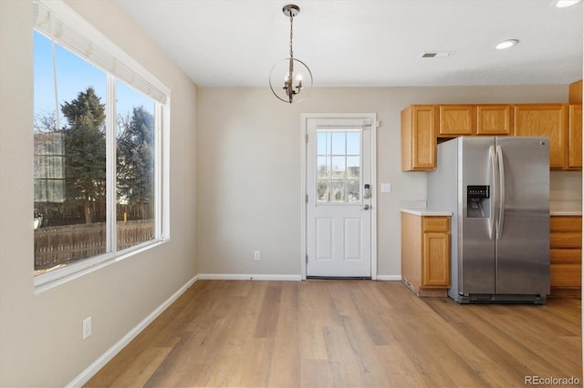 kitchen with a chandelier, stainless steel fridge with ice dispenser, hanging light fixtures, and light hardwood / wood-style floors