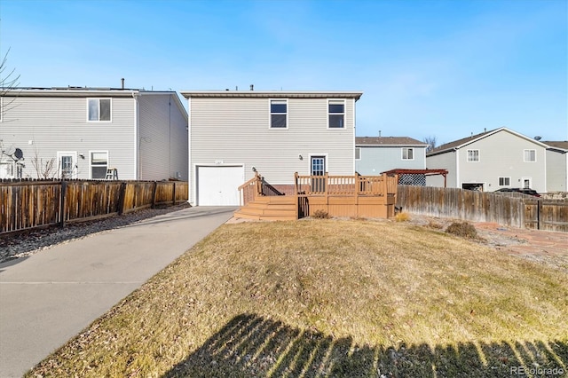 back of house with a yard, a garage, and a wooden deck