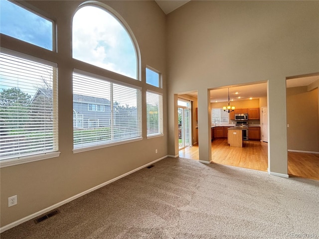 10027 Sylvestor Rd, Highlands Ranch, CO 80129 - unfurnished living room featuring light carpet, a chandelier, and a high ceiling