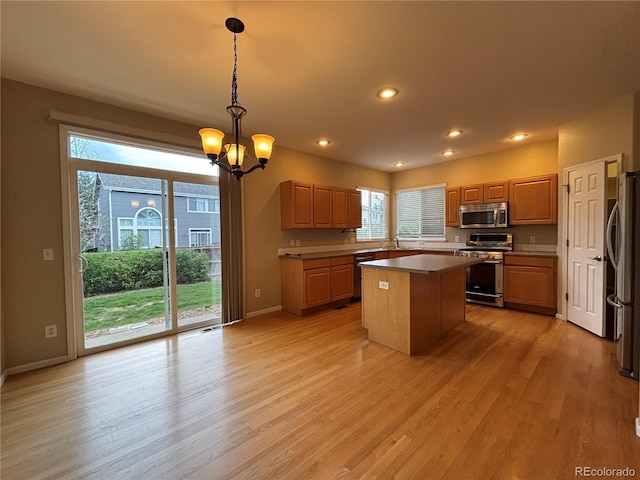 10027 Sylvestor Rd, Highlands Ranch, CO 80129 - kitchen featuring stainless steel appliances, a center island, a chandelier, light wood finished floors, and recessed lighting