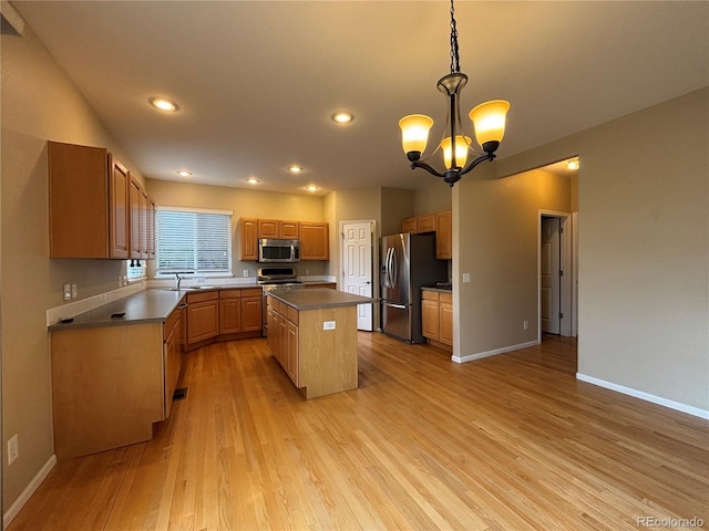 10027 Sylvestor Rd, Highlands Ranch, CO 80129 - kitchen with appliances with stainless steel finishes, a chandelier, a kitchen island, light wood-style floors, and dark countertops