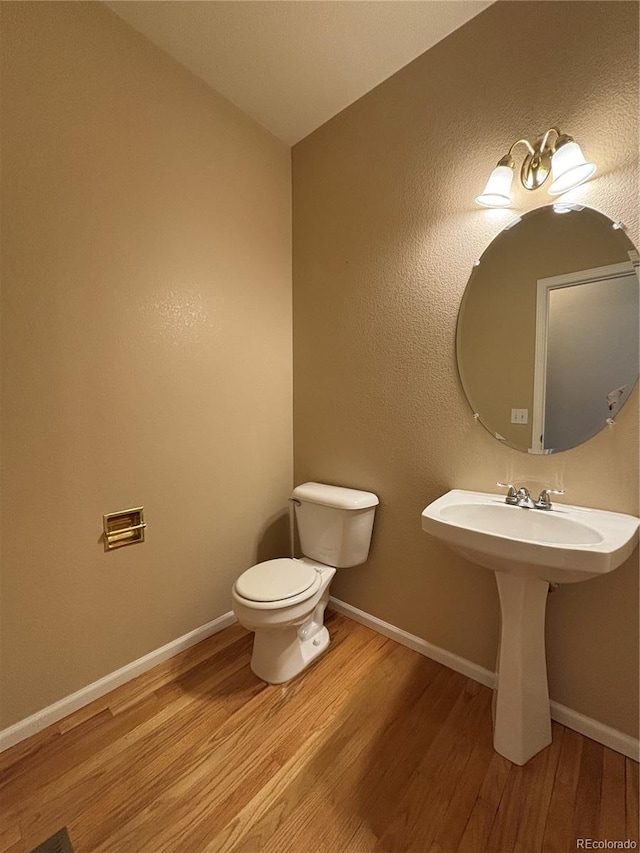 10027 Sylvestor Rd, Highlands Ranch, CO 80129 - half bath featuring wood finished floors and toilet