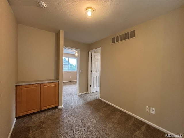 10027 Sylvestor Rd, Highlands Ranch, CO 80129 - spare room featuring a smoke detector, dark colored carpet, and a textured ceiling