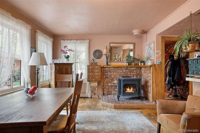 715 Main St, Georgetown, CO 80444 - living room featuring a textured ceiling, hardwood / wood-style floors, a brick fireplace, and plenty of natural light