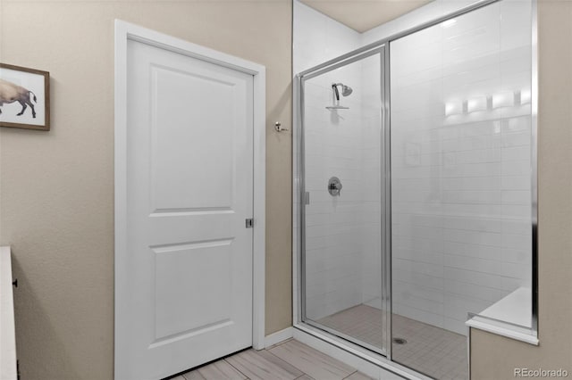 bathroom featuring a shower with door