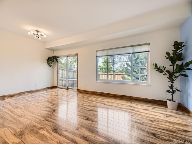 12265 E 2nd Dr, Aurora, CO 80011 - empty room with wood finished floors and a chandelier