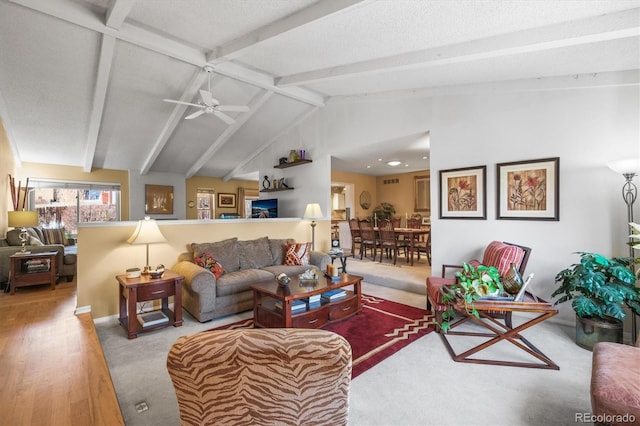 carpeted living area featuring vaulted ceiling with beams and a ceiling fan